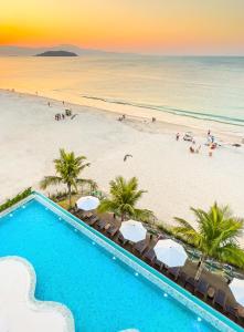 uma piscina ao lado de uma praia com palmeiras em Palace Praia Hotel em Florianópolis