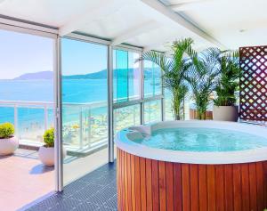 a hot tub in a room with a view of the ocean at Palace Praia Hotel in Florianópolis +87 photos
