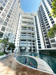 a large building with a swimming pool in front of it at The Shore Kota Kinabalu City Centre by LW Suites in Kota Kinabalu