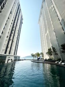 two tall buildings with a pool of water between them at The Shore Kota Kinabalu City Centre by LW Suites in Kota Kinabalu
