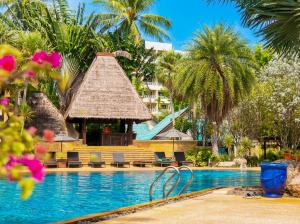 a resort pool with a gazebo and palm trees at Paradox Resort Phuket - SHA Plus in Karon Beach