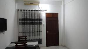 a room with a door and a curtain and a television at Villa 64 in Katunayake