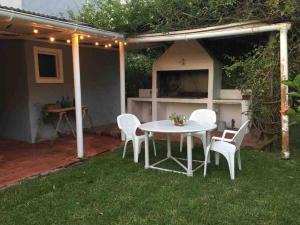 un patio con mesa y sillas en el césped en Amplia casa a cuadras del mar, en Punta del Este