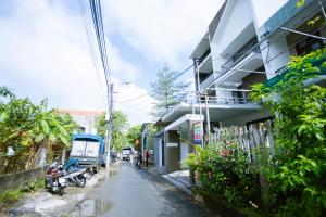 een straat naast een gebouw met een motor en een vrachtwagen bij Kennpi homestay - phòng lẻ hoặc nguyên căn in Hue