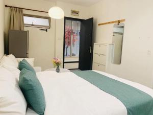 a bedroom with a large white bed with green pillows at YueShe Apartment - HongQiao Longbai Xincun in Shanghai