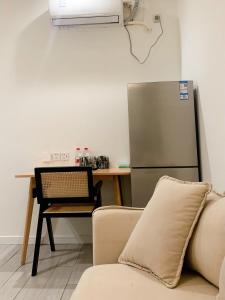 a kitchen with a couch and a table and a refrigerator at YueShe Apartment - HongQiao Longbai Xincun in Shanghai