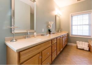a bathroom with a sink and a large mirror at 4bed/4bath Home + Spa Midway to Savannah & Tybee Island in Savannah