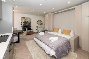 雷丁Charming Studio Flat in the Heart of Reading CHRL F1的一间带大床的卧室和一间客厅