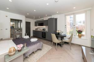 雷丁Charming Studio Flat in the Heart of Reading CHRL F1的厨房和客厅，配有一张床和一张桌子