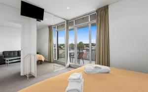 a bedroom with a bed and a view of a balcony at 412, 162 Hindmarsh Rd, Victor Harbor in Victor Harbor +13 photos