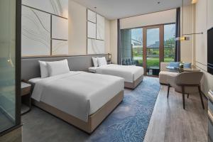 a hotel room with two beds and a desk at Crowne Plaza Ganzhou, an IHG Hotel in Ganzhou