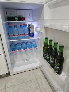 an open refrigerator filled with bottles of water and drinks at SLEEP & GO in Surčin