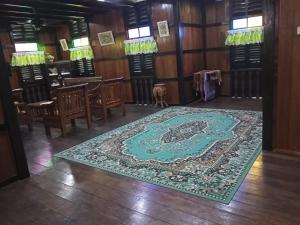 comedor con alfombra en el suelo en Azli homestay, en Tampin