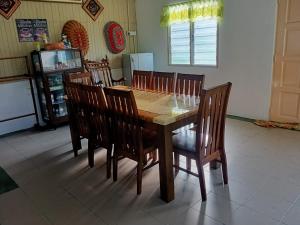 a wooden dining room table and chairs in a kitchen at Azli homestay in Tampin