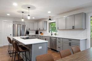 a kitchen with white cabinets and a kitchen island at The Lofts on Indian Point - Near Silver Dollar City in Branson