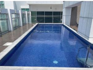 a large blue swimming pool in front of a building at Riversuits#1 Santa Ana in Guayaquil