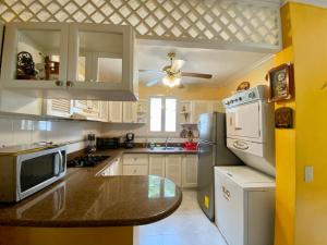 uma cozinha com armários brancos e um balcão preto em Casa Blanca - Altos del Mar em Same