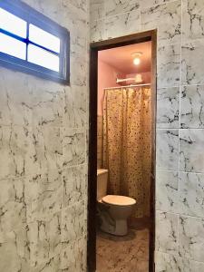uma casa de banho com um WC e um chuveiro em Suíte / Falesias de Carapibus em Conde