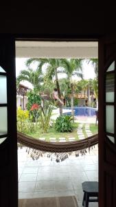 uma vista para uma piscina a partir da porta de um resort em Suíte / Falesias de Carapibus em Conde