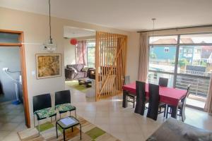 comedor y sala de estar con mesa roja y sillas en Close to airport: 2 bedroom home, spacious & cosy en Entebbe
