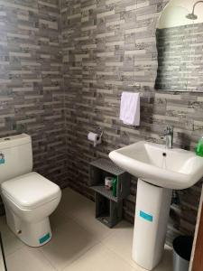 łazienka z toaletą i umywalką w obiekcie Close to airport: 2 bedroom home, spacious & cosy w mieście Entebbe