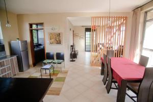 cocina y comedor con mesa roja y sillas en Close to airport: 2 bedroom home, spacious & cosy en Entebbe