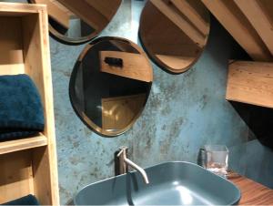La salle de bains est pourvue d'un lavabo et d'un miroir. dans l'établissement Maison capsule, au Monêtier-les-Bains