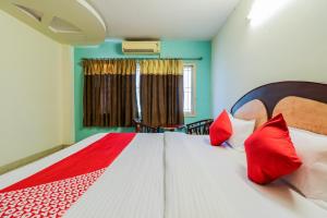 een slaapkamer met een groot bed met rode kussens bij Parnasala Princely in Rājahmundry