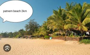 a beach with palm trees and a speech bubble at CASA FIESTA guest House in Palolem