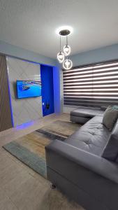 RES. CORAL في بورلامار: غرفة معيشة مع أريكة والجدار الأزرق