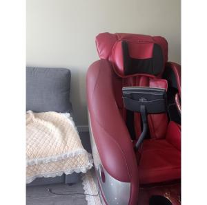 a red car seat sitting next to a couch at A comfy place with entertainment best for vacation or business trip in Richmond