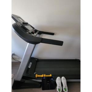 a treadmill in a room with two pairs of shoes at A comfy place with entertainment best for vacation or business trip in Richmond