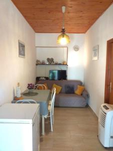 ein Wohnzimmer mit einem Tisch und einem Sofa in der Unterkunft Apartments Tonci - 30 m from beach in Kali