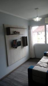 Schlafzimmer mit einem Bett und einem Wandspiegel in der Unterkunft Excelente Apto 2 quartos, condomínio fechado, com vaga estacionamento in Pelotas