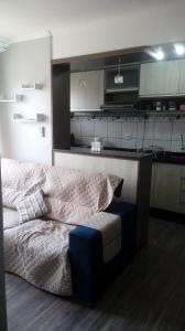 ein Wohnzimmer mit einem Bett und eine Küche in der Unterkunft Excelente Apto 2 quartos, condomínio fechado, com vaga estacionamento in Pelotas