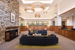 a lobby with couches and a stone fireplace at Yarra Valley Lodge in Wonga Park