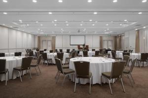 a conference room with tables and chairs and a screen at Yarra Valley Lodge in Wonga Park