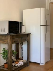 a microwave sitting on a table next to a refrigerator at CASA CANGAS in Belén de Escobar +17 photos