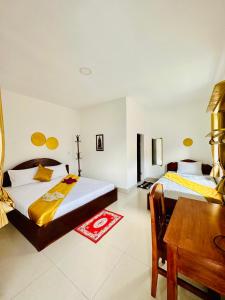 1 dormitorio con 2 camas, escritorio y mesa en Apsara Koh Rong Guesthouse en Koh Rong Island