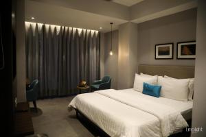グレーター・ノイダにあるBelvedere Suitesのベッドルーム1室(ベッド1台、椅子2脚、窓付)