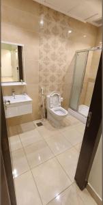 a bathroom with a toilet and a sink and a shower at الجوهرة البيضاء للشقق المخدومة in Jeddah