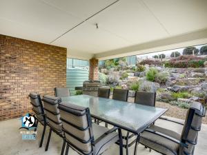 a dining room with a glass table and chairs at Sweeping Ocean Views 4BR on One Acre in Encounter Bay
