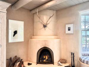 Una sala de estar con chimenea con una cabeza de insecto en la pared. en Casa TATIZ • Privacy in a Southwestern Gem, en Santa Fe
