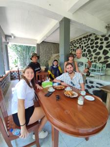 a group of people sitting around a wooden table at Peno Homestay in Sumberbuluh