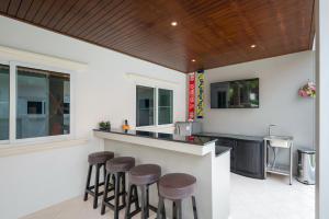 una cocina con barra con taburetes en un mostrador en Orchid Paradise Homes OPV 30, en Hua Hin