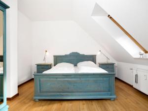 1 dormitorio con 1 cama azul en el ático en Residenz am Yachthafen Möwenblick, en Kirchdorf