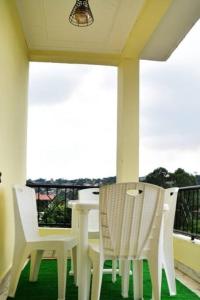 un tavolo bianco e sedie sul balcone di Appartement meublé, 2 douches, 2 chambres a Yaoundé