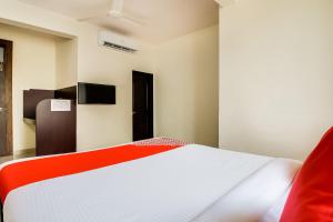 een slaapkamer met een wit bed en een rode deken bij OYO Hotel Galaxy Near INOX in Yeraoda