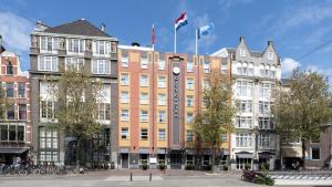 ein Gebäude mit zwei Flaggen darüber in der Unterkunft WestCord City Centre Hotel in Amsterdam