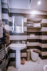 a bathroom with a sink and a toilet and a mirror at La Loggia del Mercante in Orvieto